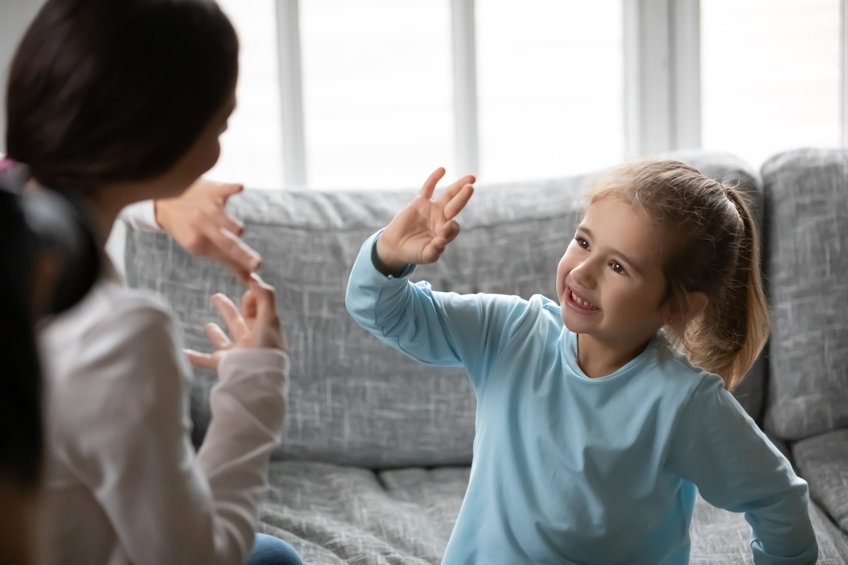 Close up deaf little girl communicating with mother