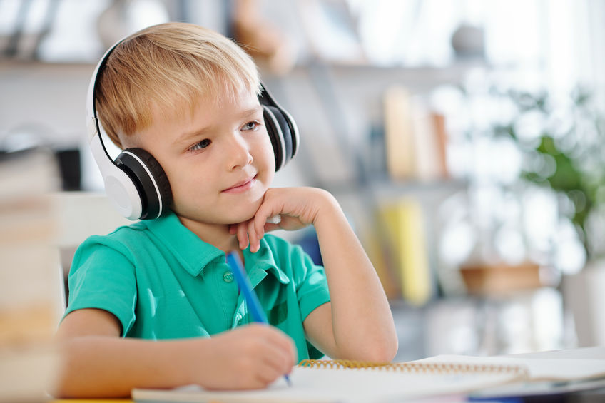 Cute schoolboy enjoying music